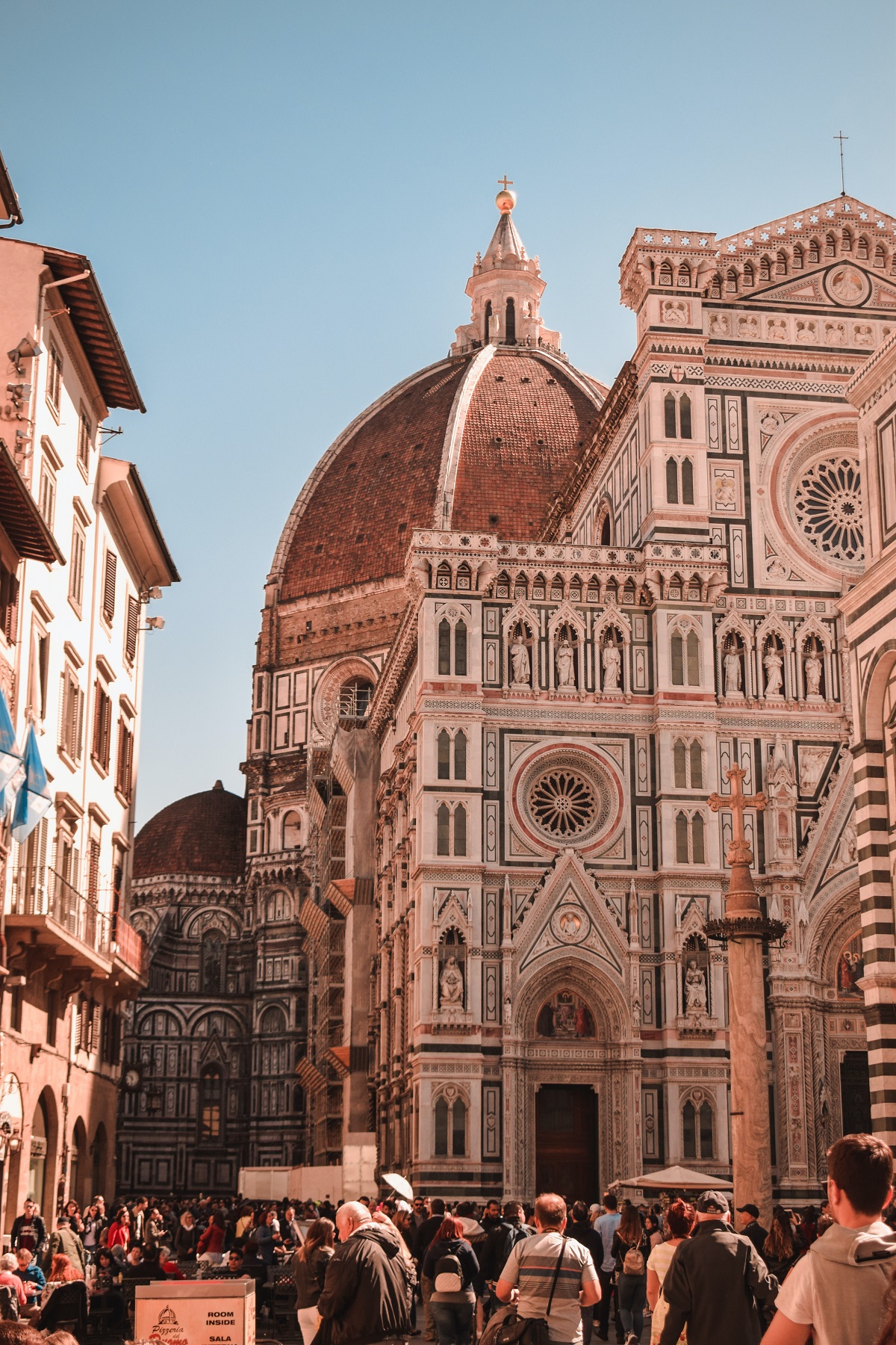 Crowds of tourists surround the Duomo in Florence on a sunny summer day