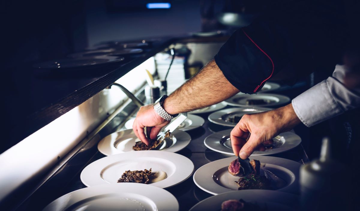 man plating dishes