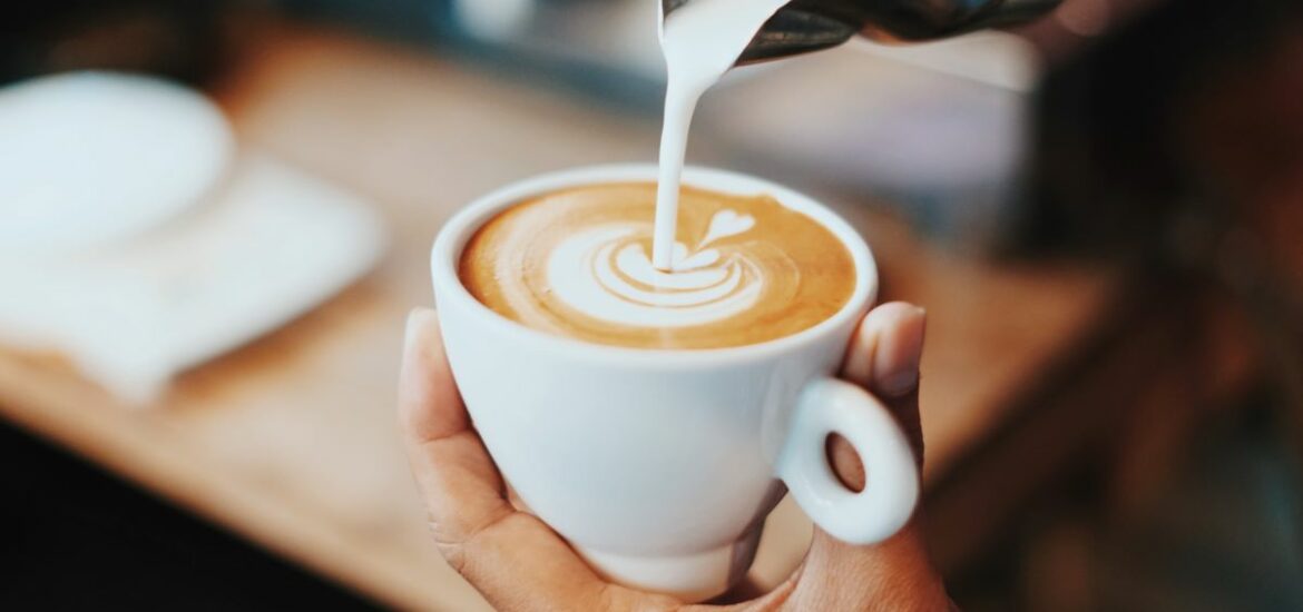 Milk poured into coffee creates a beautiful latte art design.
