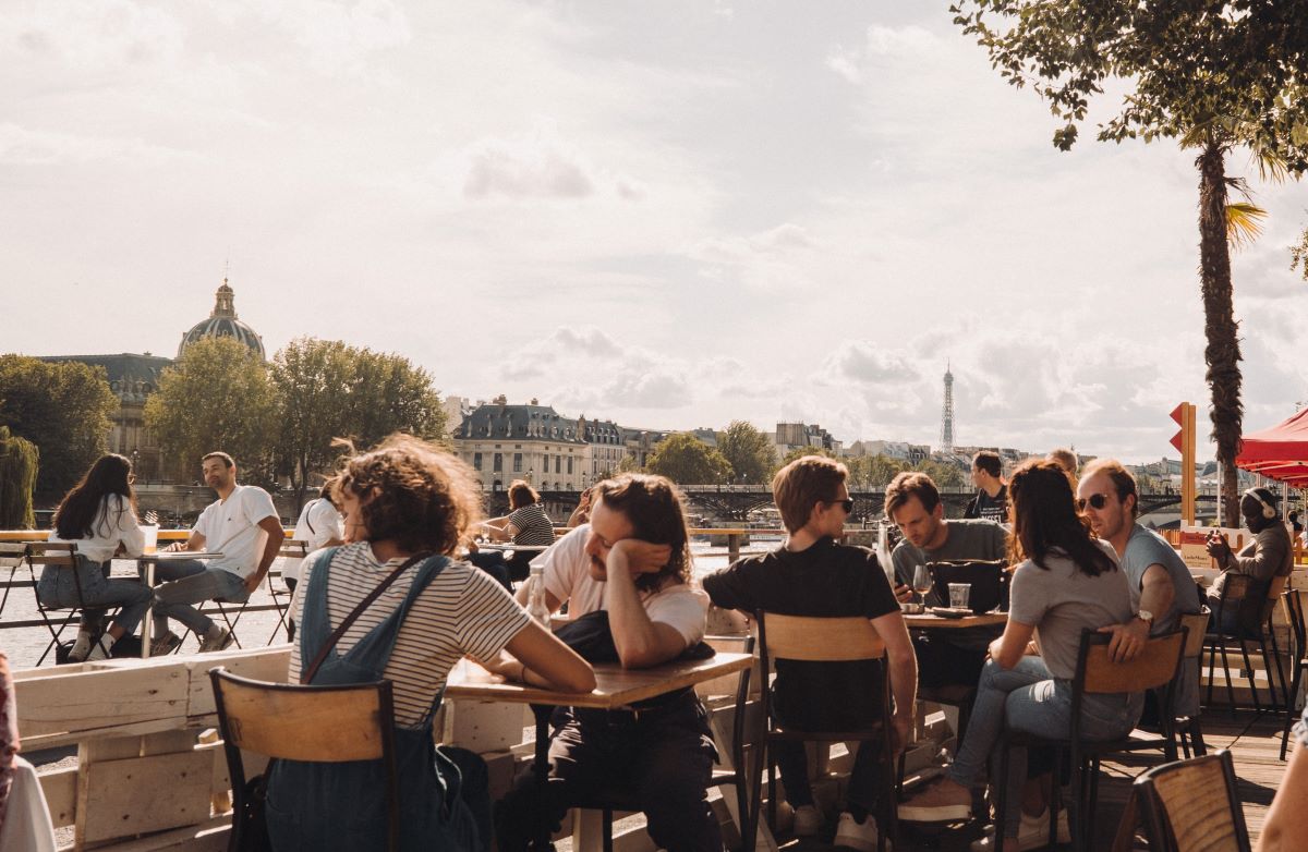 People sitting outside in Paris enjoying food at a famous restaurants