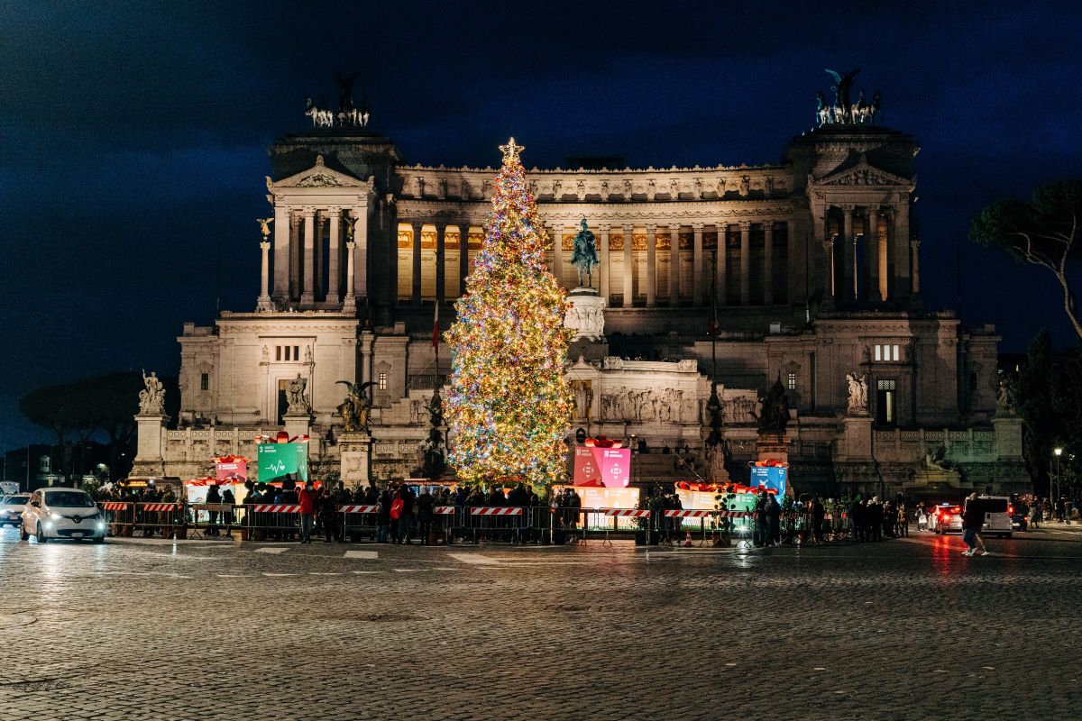 A large christmas tree in front of a building in Rome. 