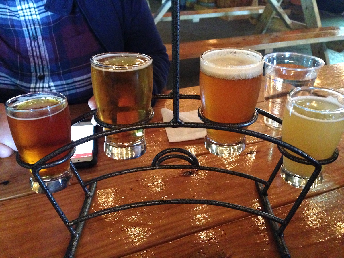 Flight of four beers in a wire rack