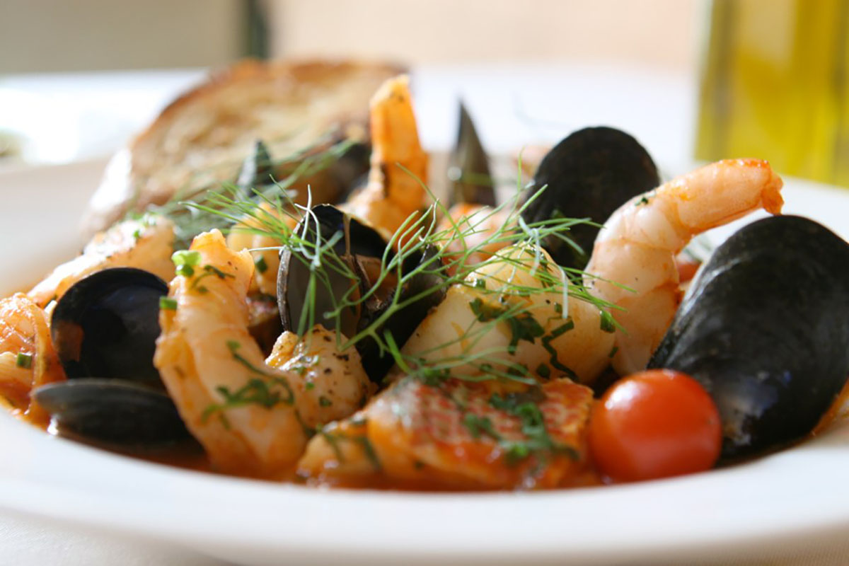 mussels shrimp and tomatoes in white plate