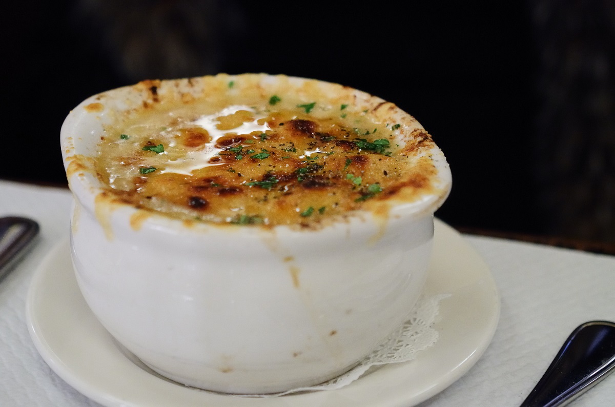 Close up of french onion soup in a white porcelain bowl