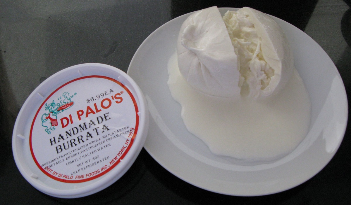 Ball of burrata split open with two halves on a plate