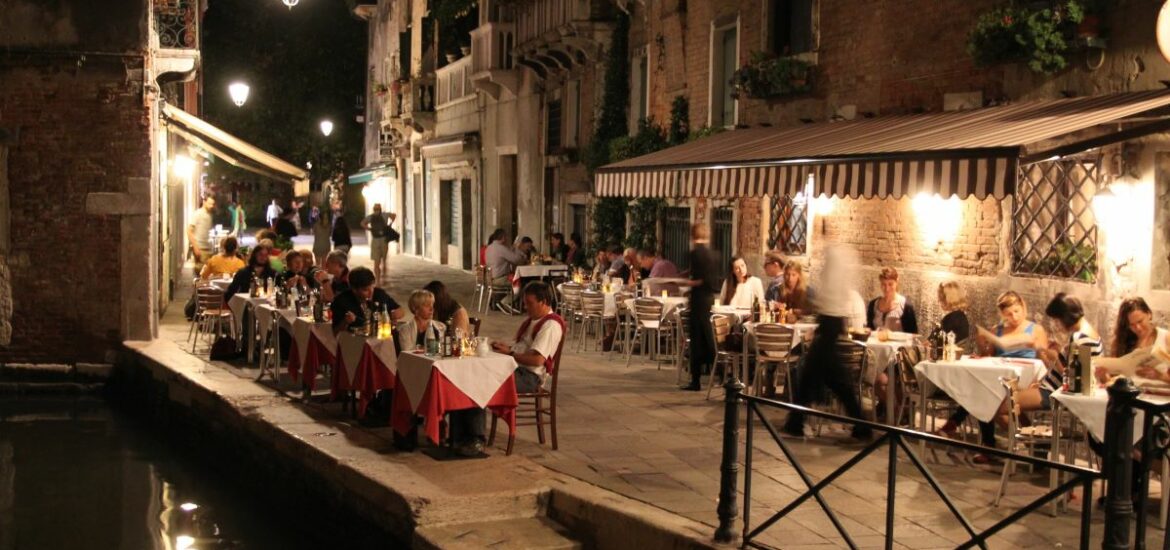 people seating at restaurant at night by canal