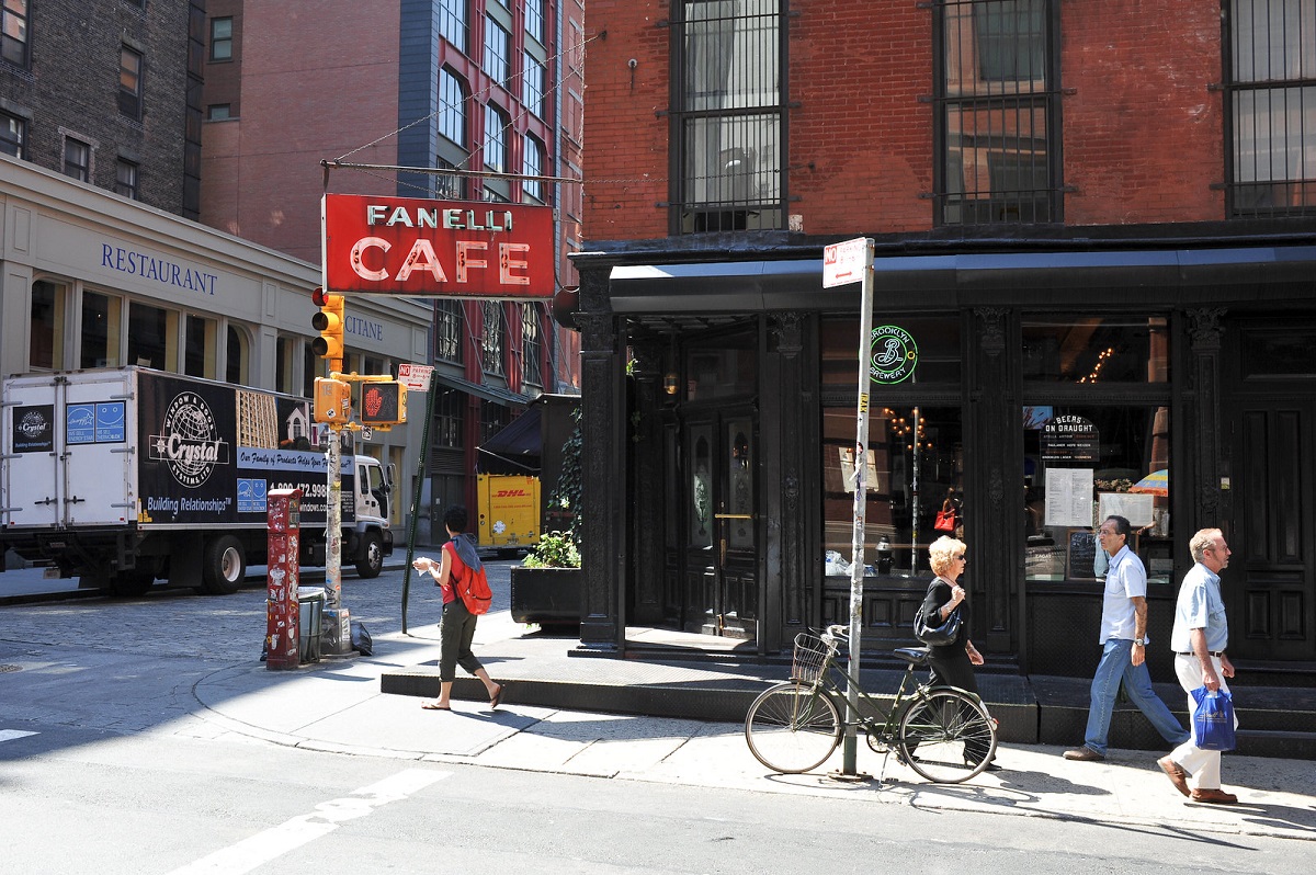 Exterior of restaurant with a sign that reads Fanelli Cafe with pedestirans in the foreground