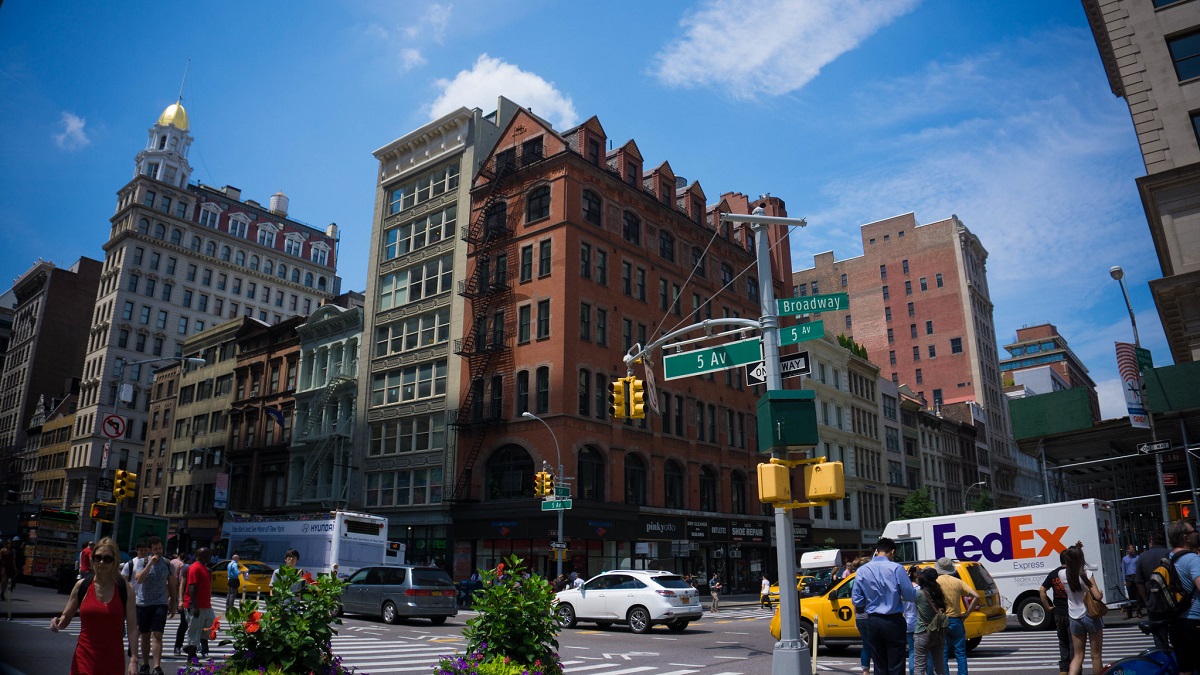 Tall brick buildings above streets with cars in New York