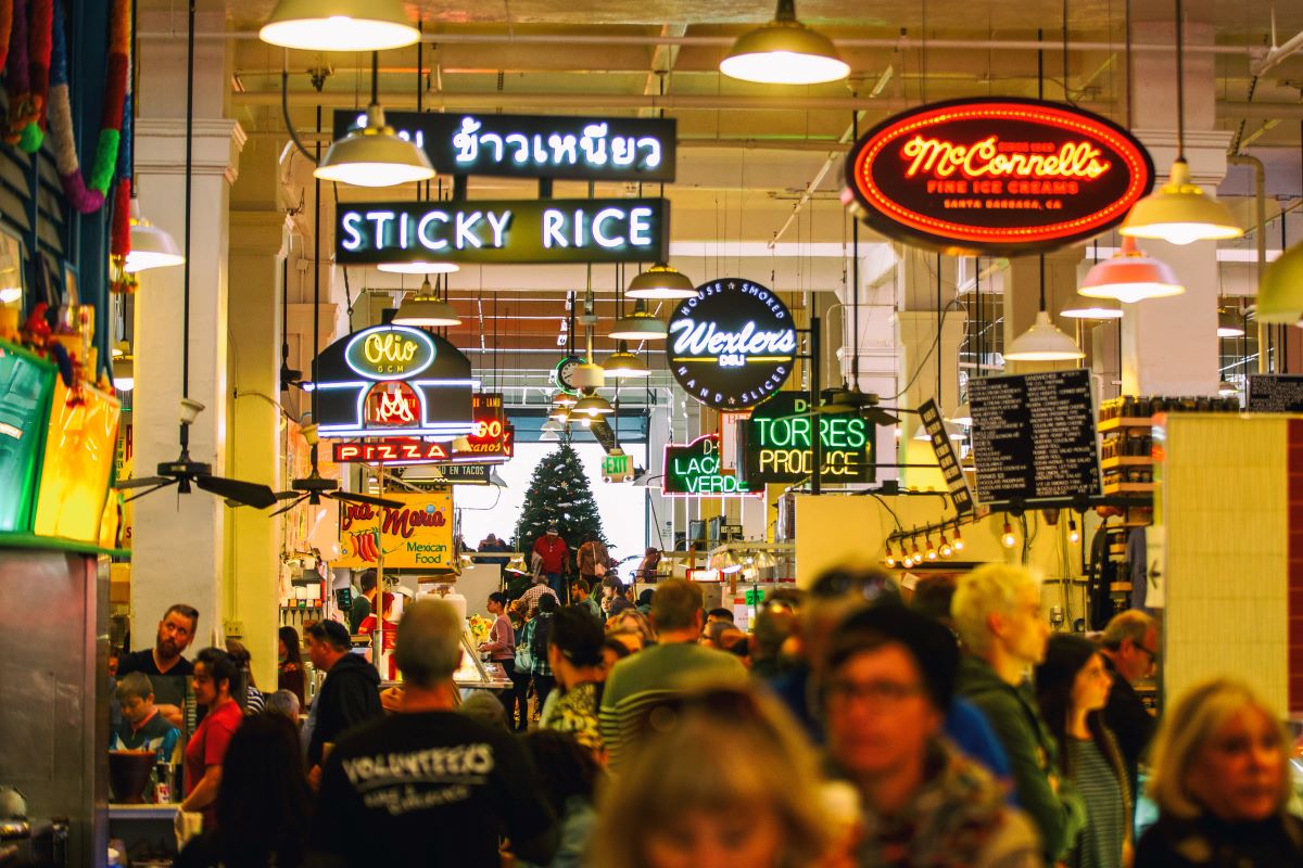 busy market hall with neon signs