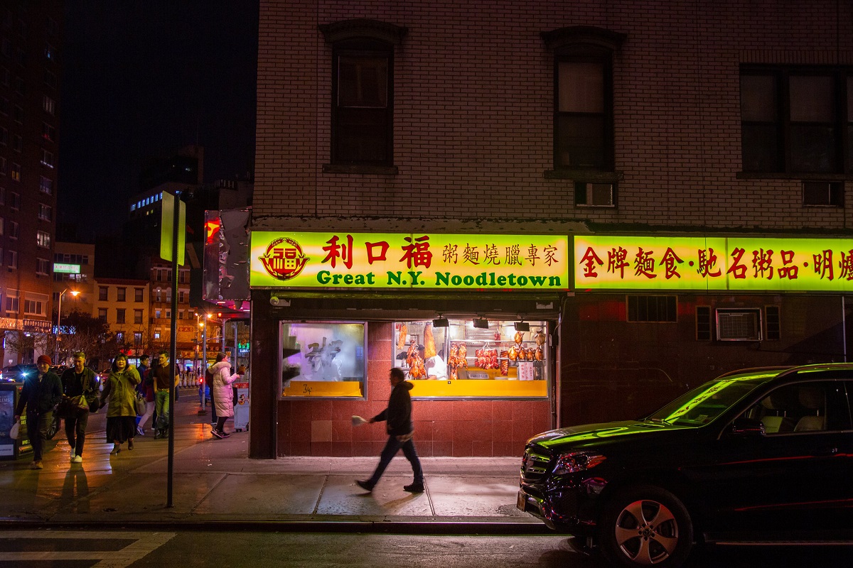 Man walks outside of Chinese restaurant in Manhattan's Chinatown at night