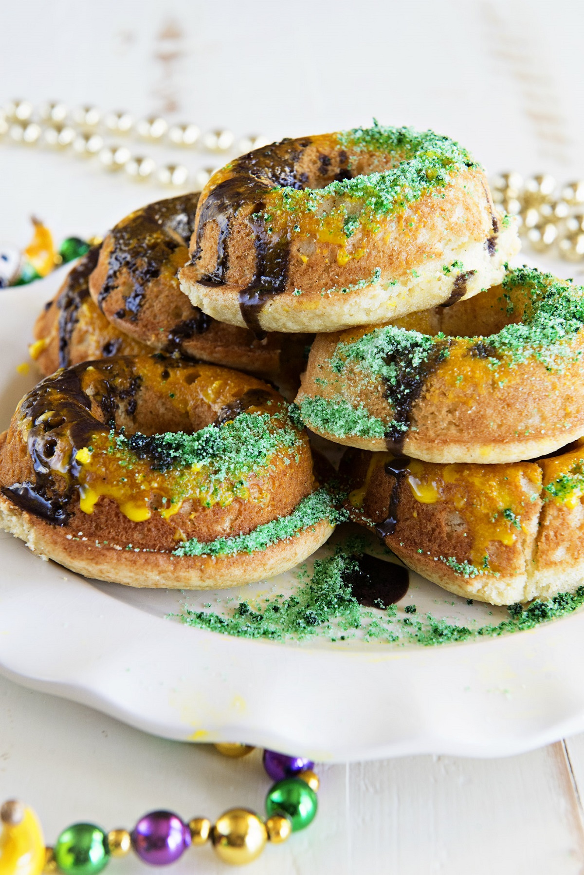 Platter of mardi gras donuts with beads and bright colors and sprinkles