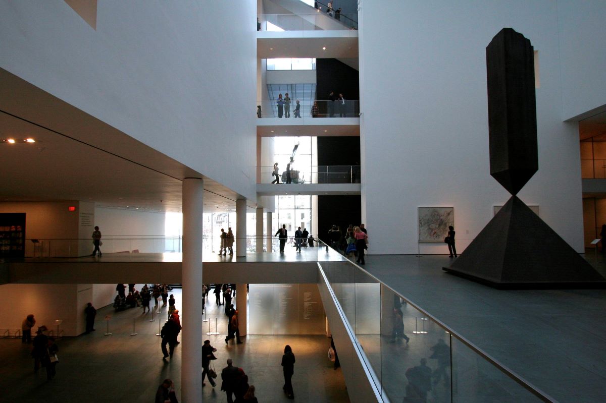 people walking around the entrance hall of moma museum