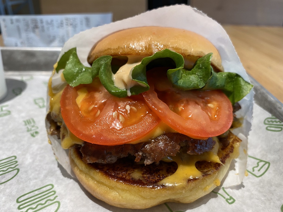 Small burger from Shake Shack with sauce, lettuce, and tomatoes