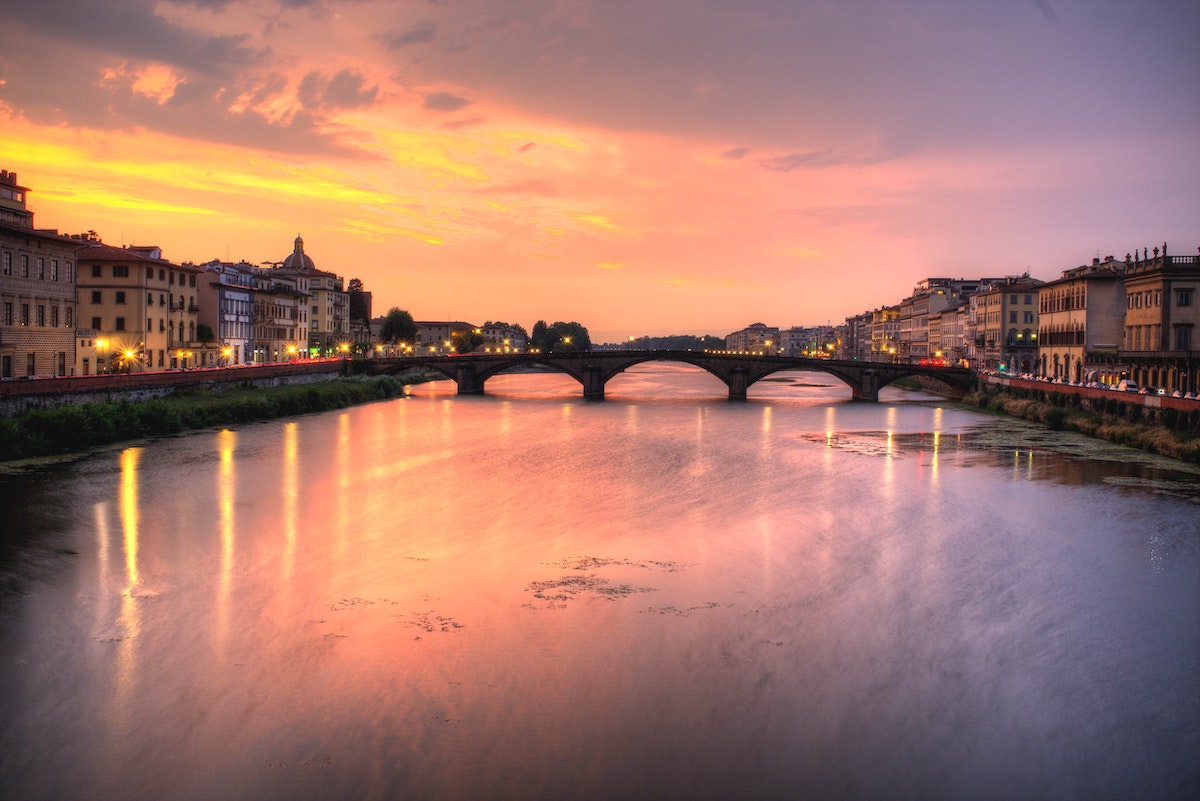 Sunset over the Arno River in Florence with a bridge in the background