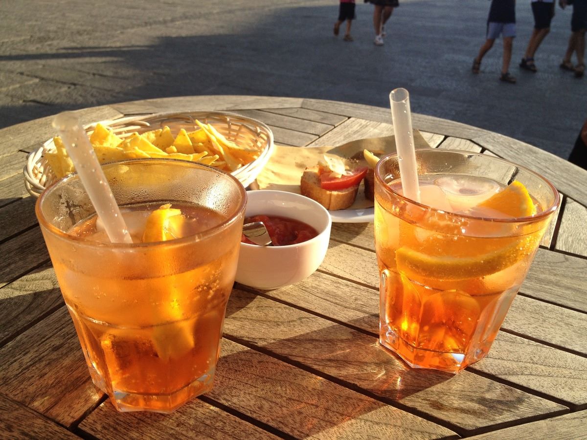 spritz chips and olives on wooden table outside
