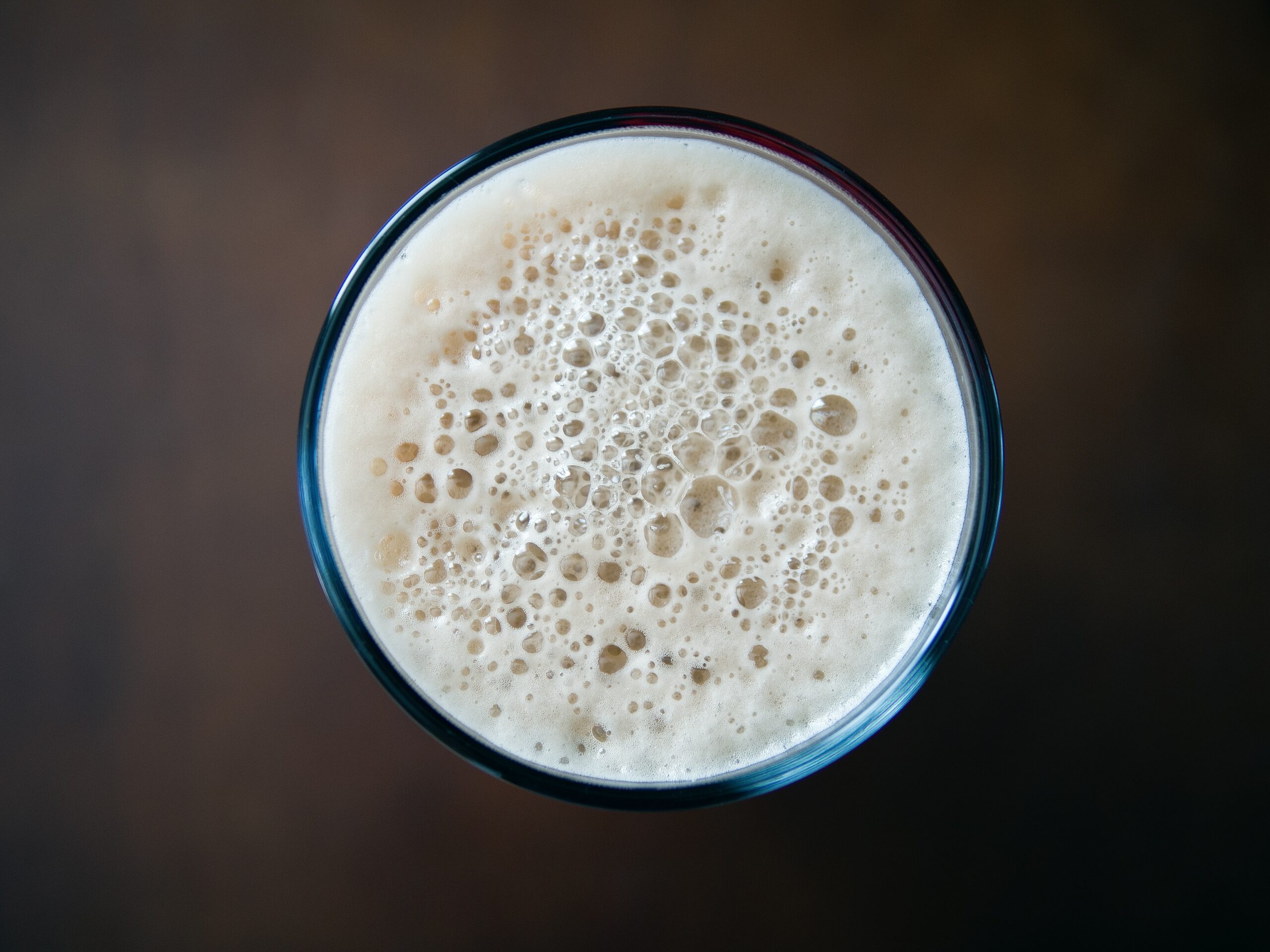 A glass of beer with foam