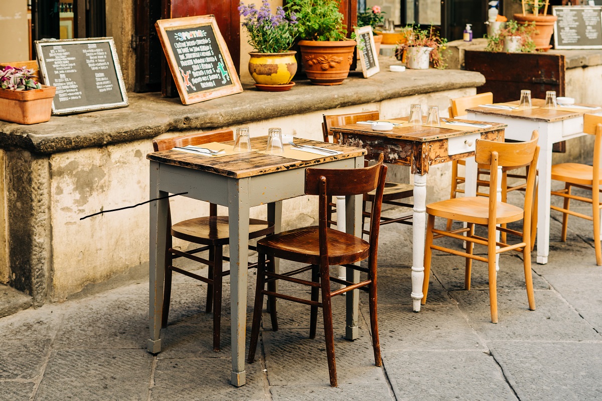 small wooden table at casual outdoor terrace restaurante in florence, italy