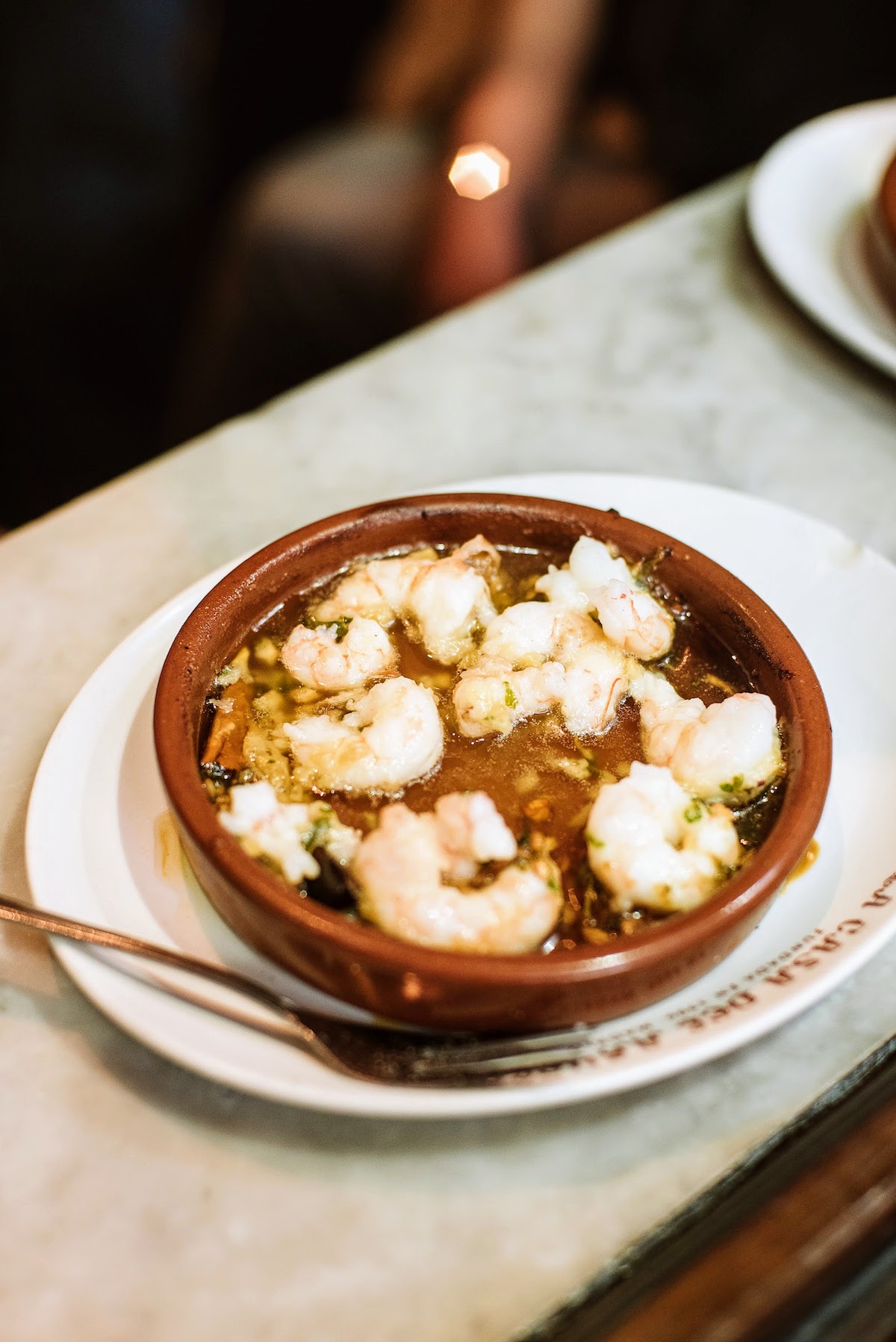 Garlic shrimp in a small clay dish.