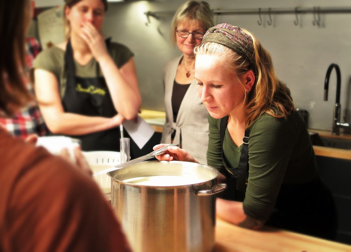 woman watching over large pot in cooking class