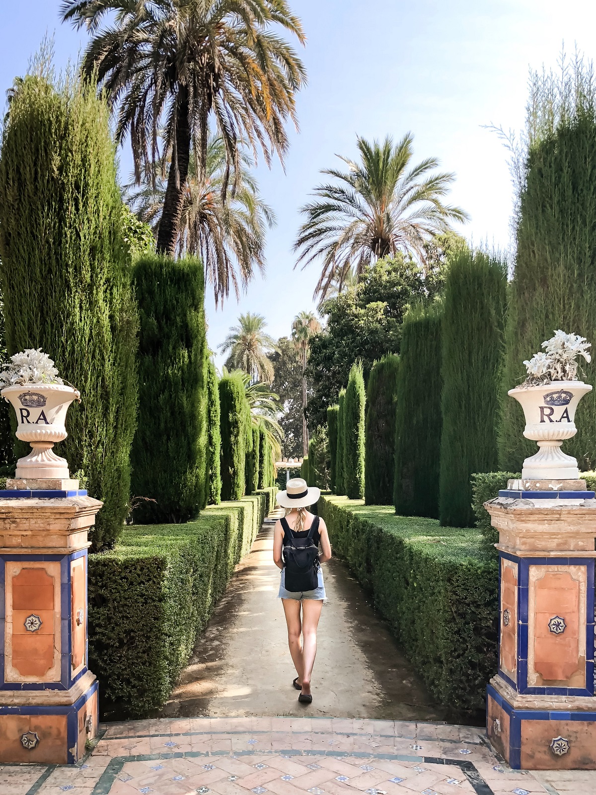 Woman strolling between columns at a park on a sunny summer day in southern spain