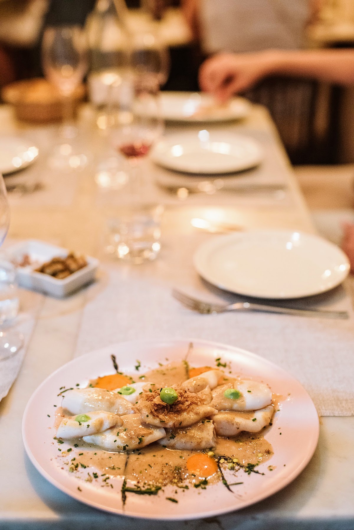 Grilled calamari with Iberian ham sauce on a white plate atop a restaurant table