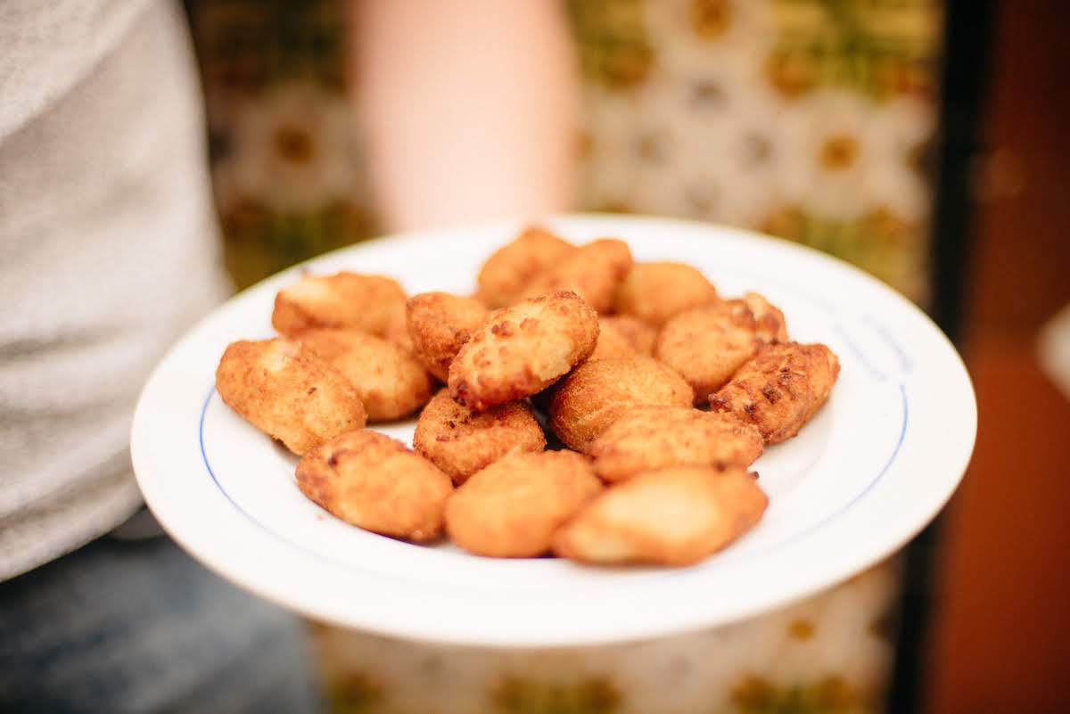 Several fried croquettes on a white plate.