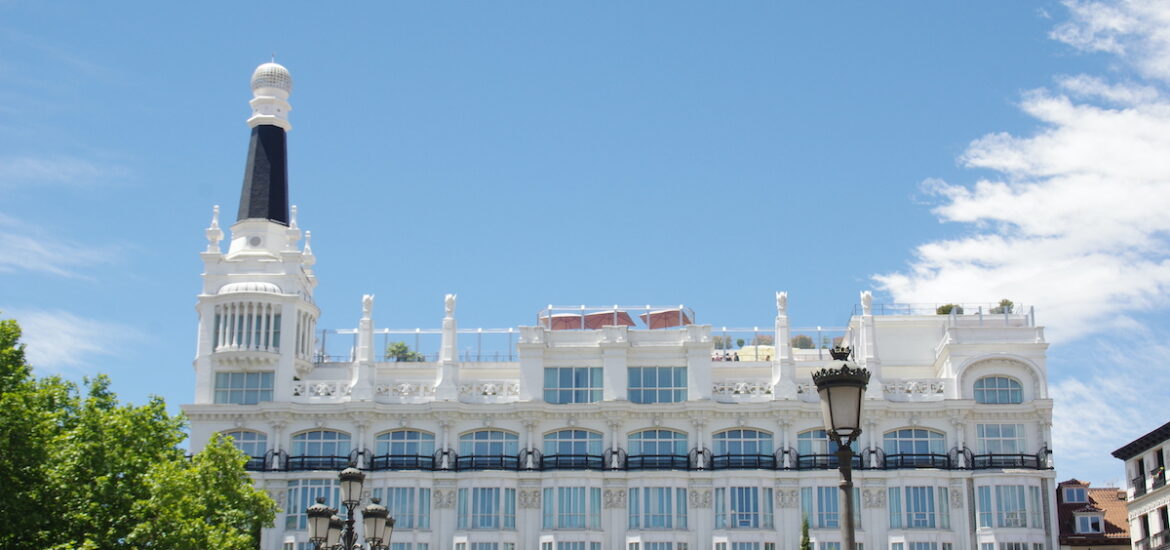 Exterior of a large white hotel on a clear day.