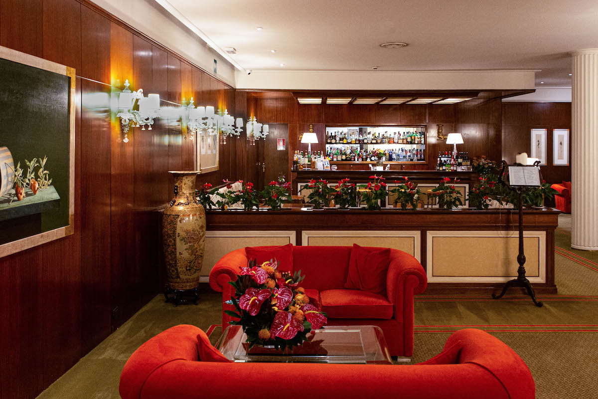 Hotel bar with red couches and wood-paneled walls