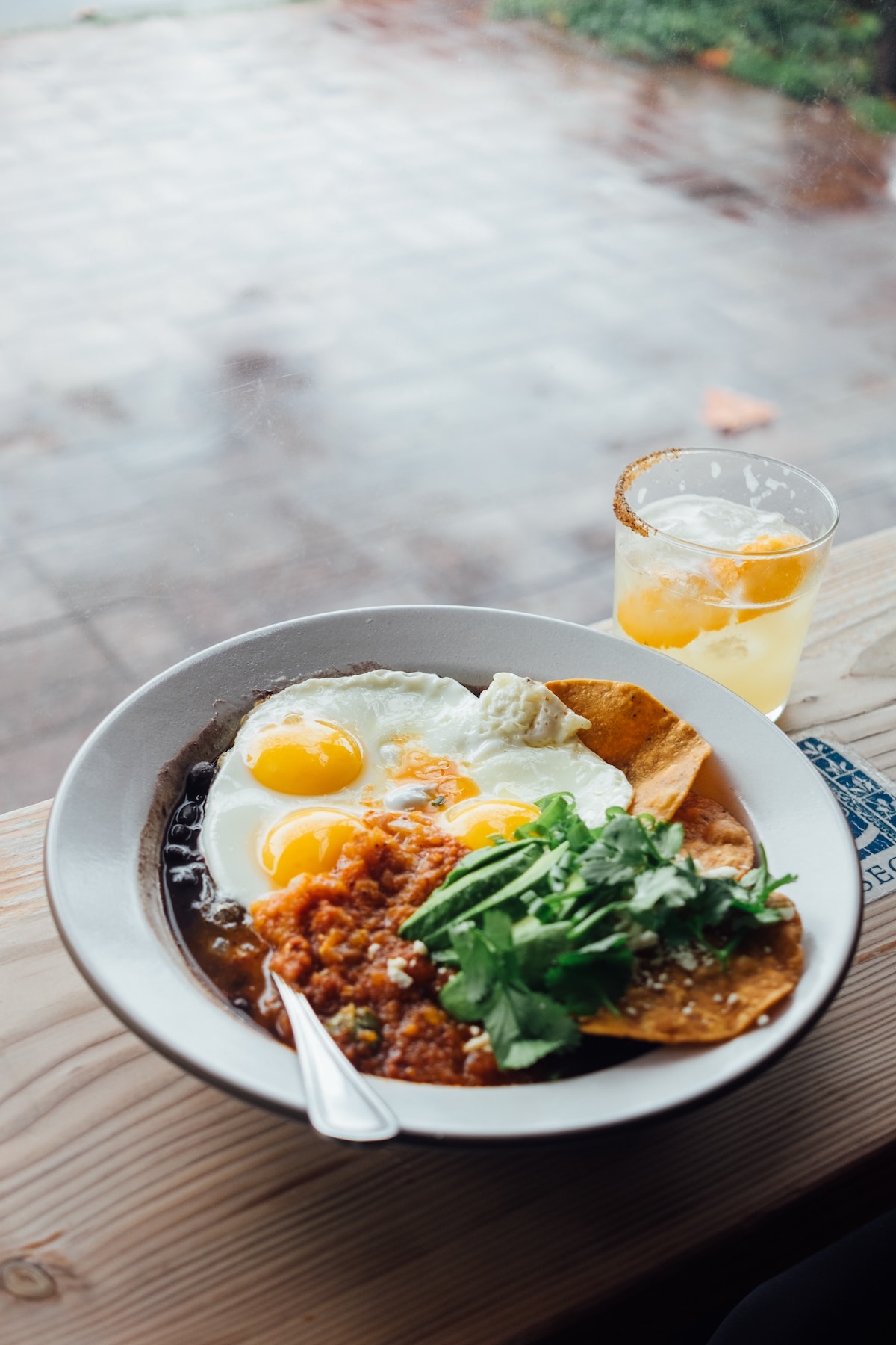 Overhead shot of vegetarian huevos rancheros in a white bowl. A delicious option for vegetarian brunch in Madrid.