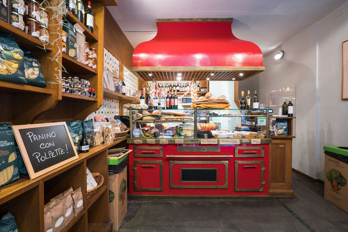 Interior of a bakery-style restaurant with red details around the counter space