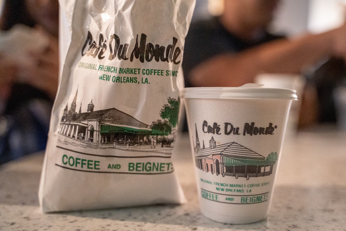A paper takeaway bag and styrofoam coffee cup from Cafe Du Monde