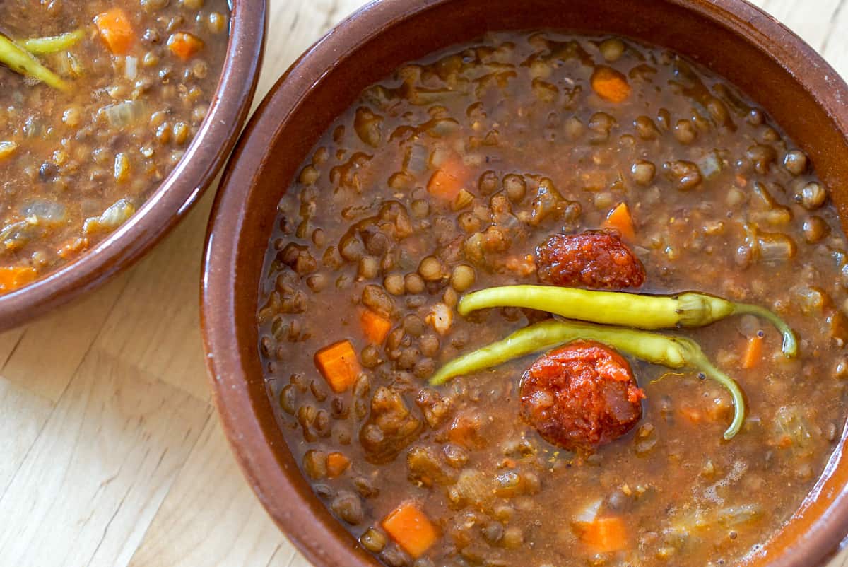 Bowl of lentil soup with chorizo and green pickled peppers