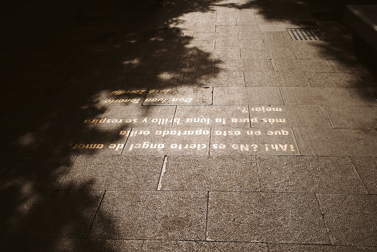 Stone street with a Spanish quote inlaid in gold letters.