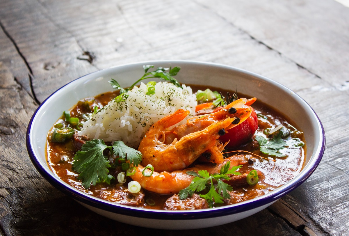 Indonesian dish with sauce, shrimp, rice, cilantro, and spices