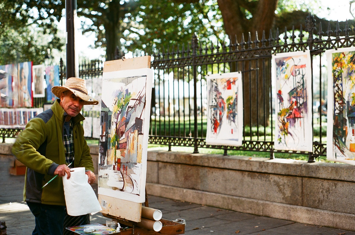 Artist paints landscape paintings outdoors in New Orlean's Jackson Square