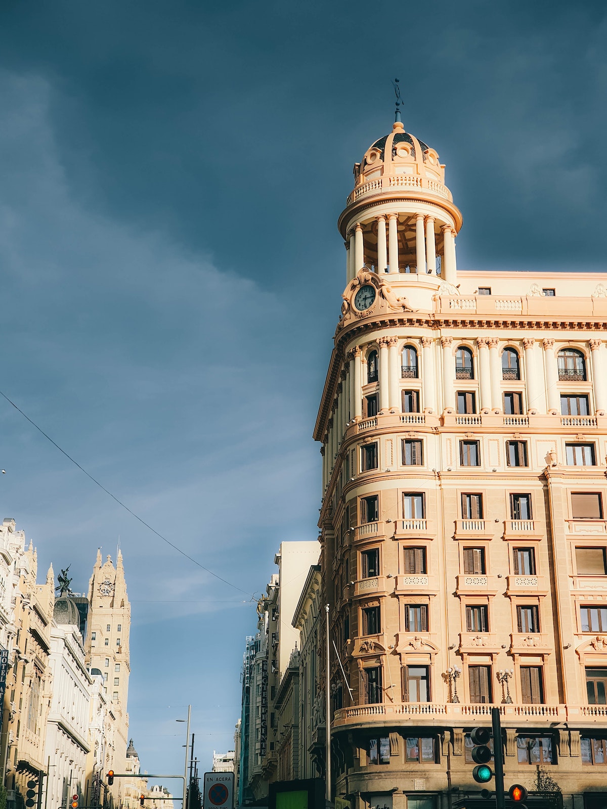 Exterior shot of tall beige stone building on a street corner.