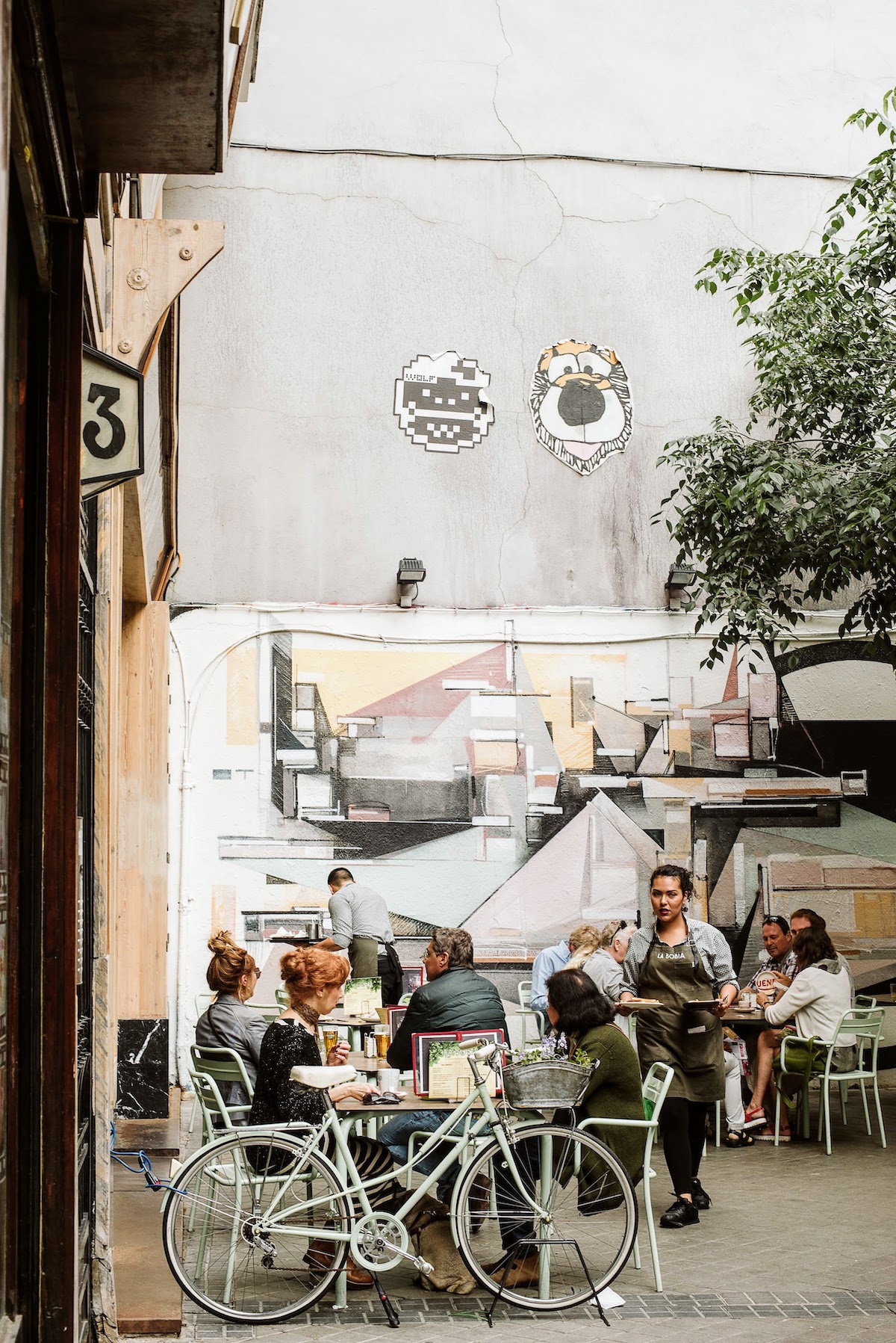 People eating and drinking on an outdoor bar terrace.