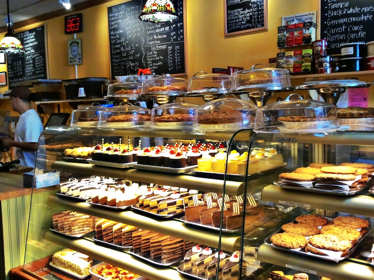 Variety of pastries and other baked goods displayed in a glass case at a bakery counter