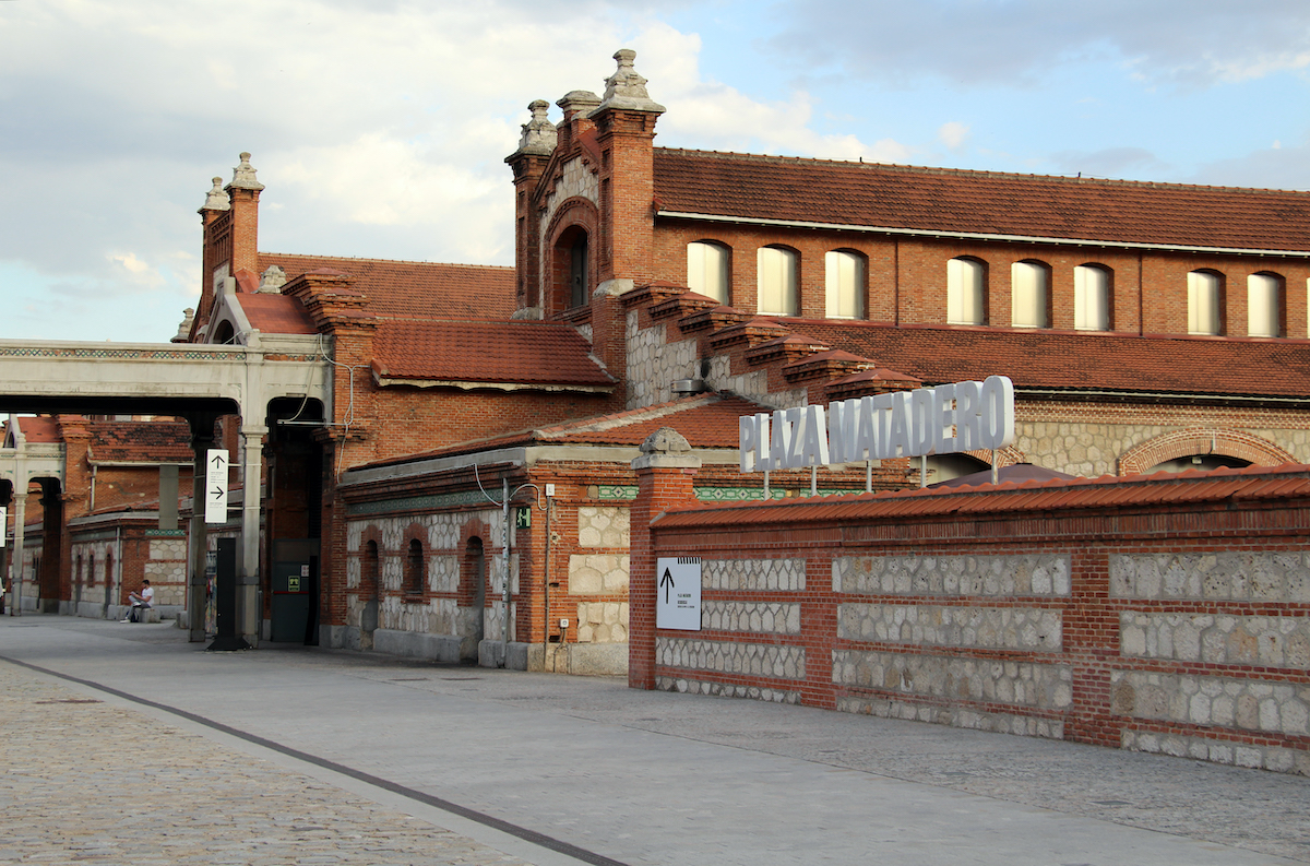 Large brick and stone building with a white lettered sign reading Plaza Matadero.