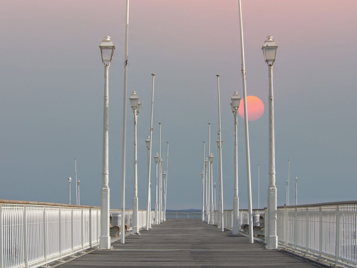 A pink moon in the sky over the beach