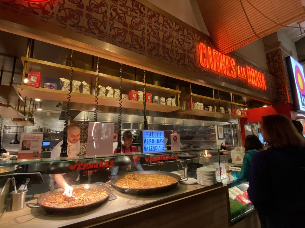 Market stall with two large pans of paella on the counter