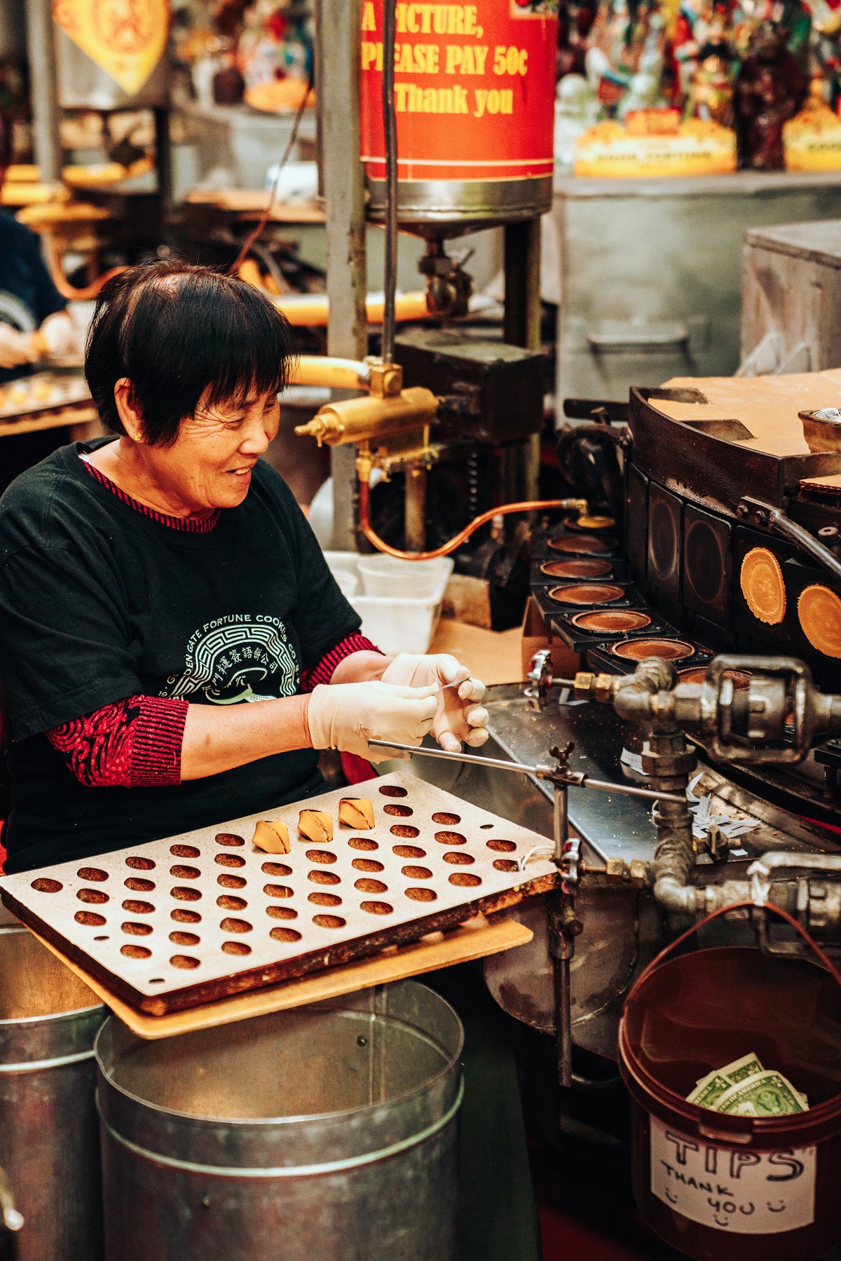 Food service employee folding cookies at the Golden Gate Fortune Cookie Factory