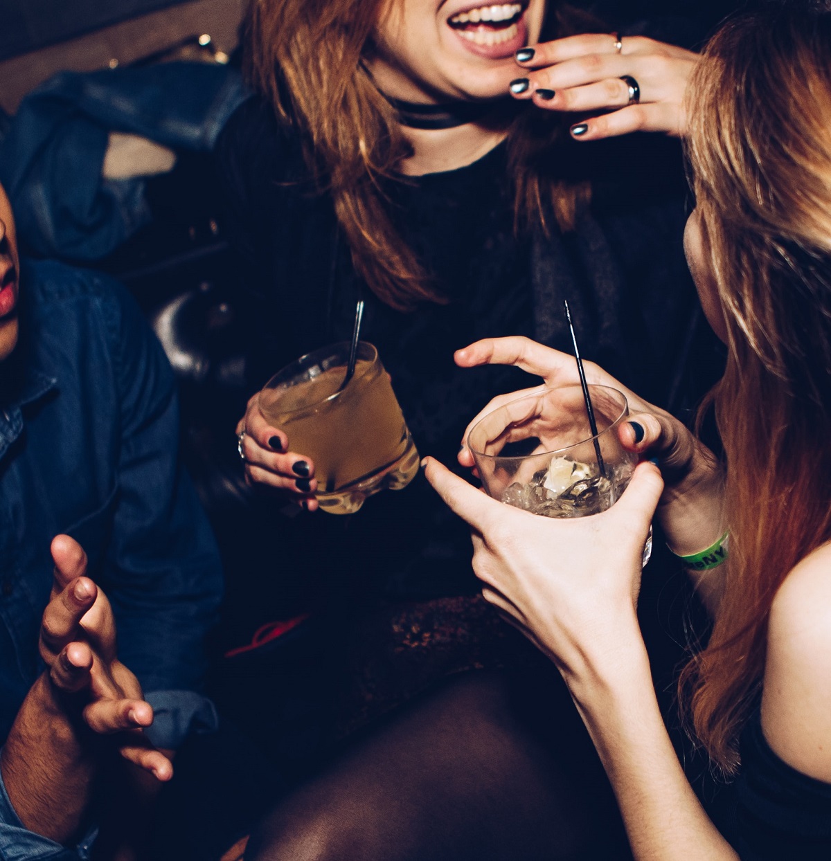 Friends dancing at a club with mixed drinks in hand