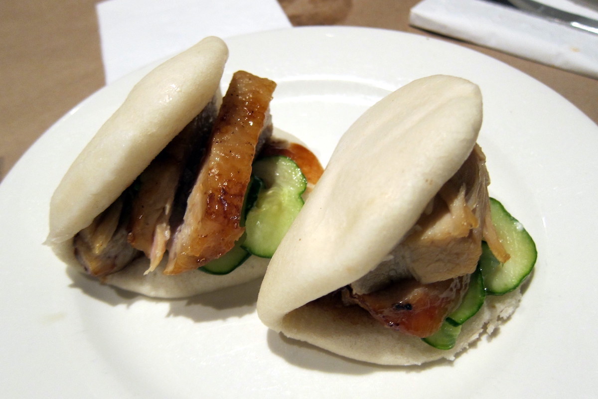 Two bao buns filled with crispy pork and cucumber