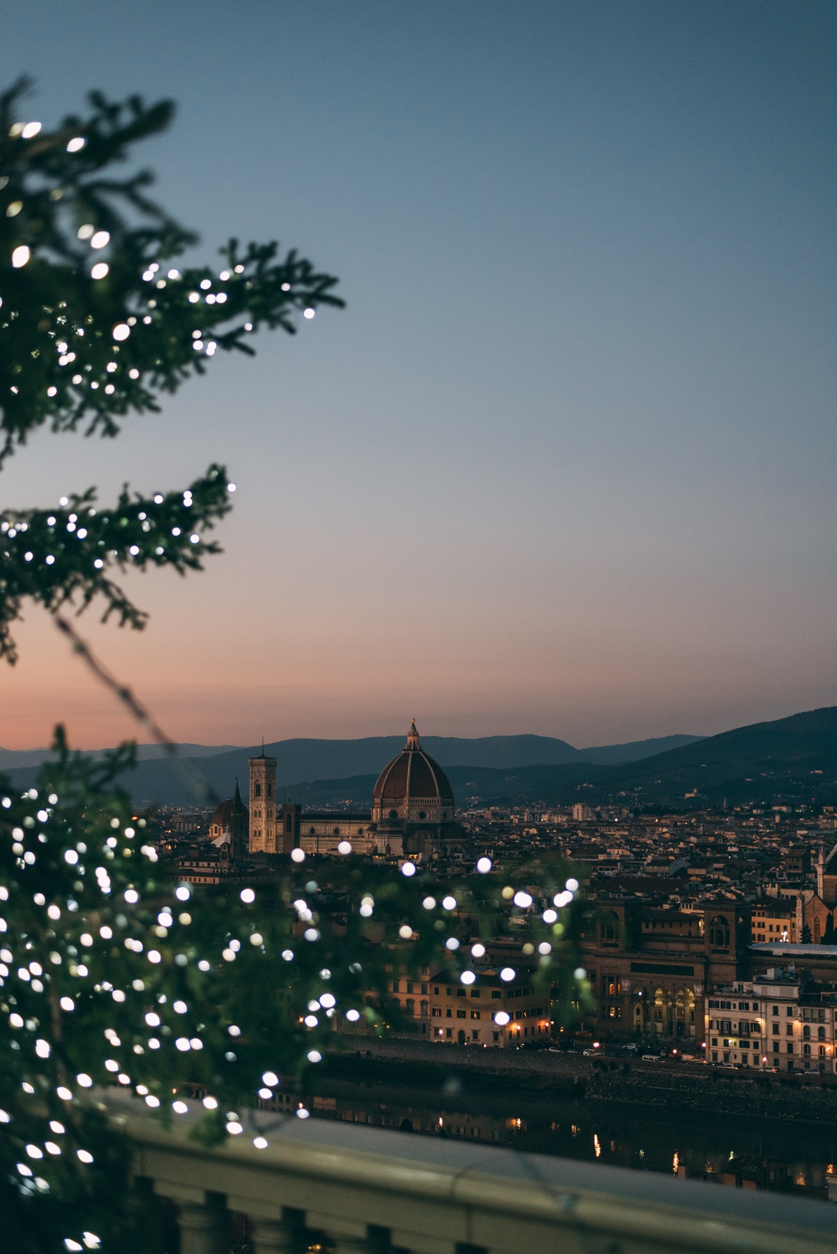 Florence in winter with holiday lights, as seen from the top of a hill