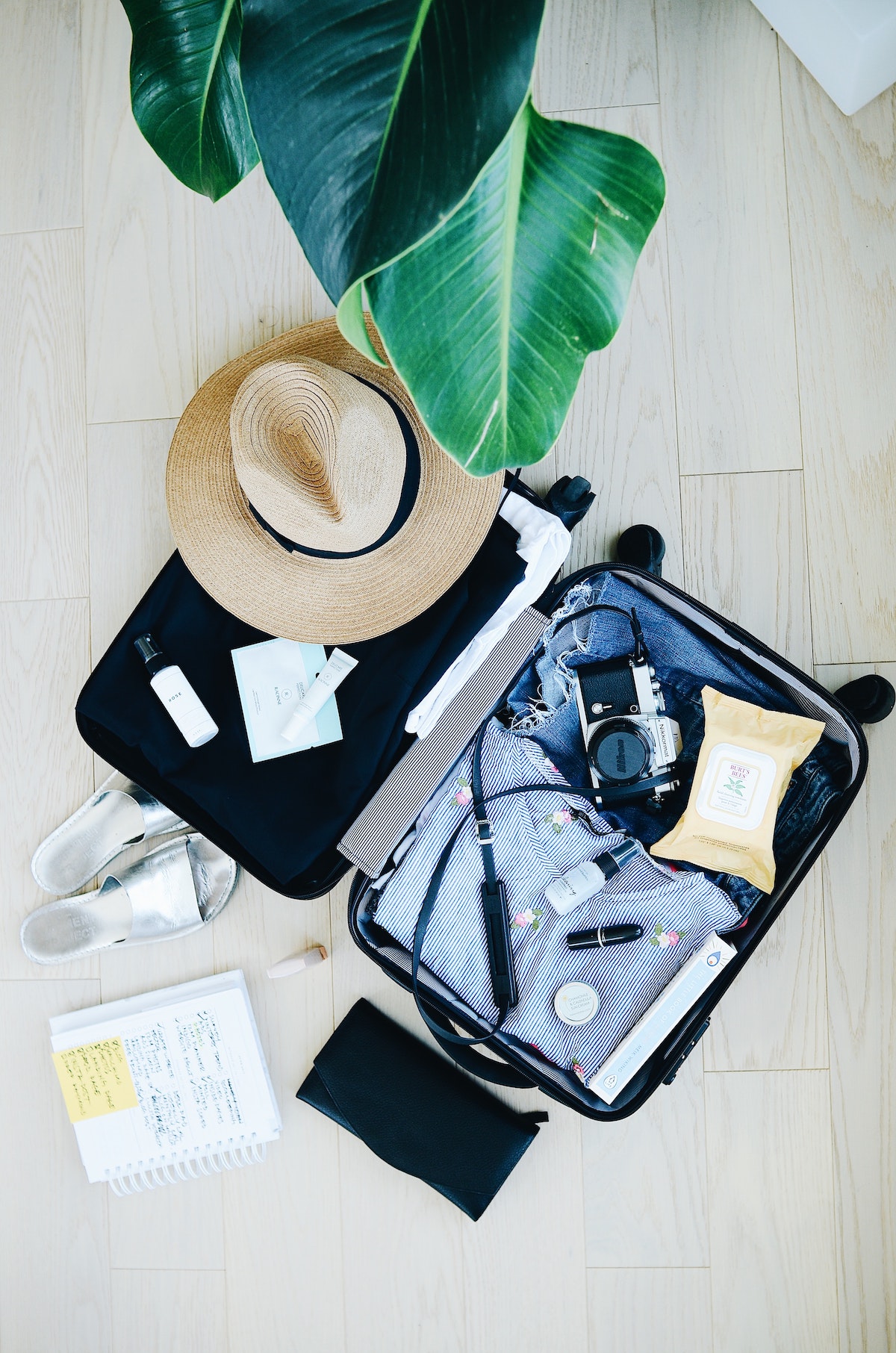 Overhead view of an open suitcase with items spilling out onto the floor