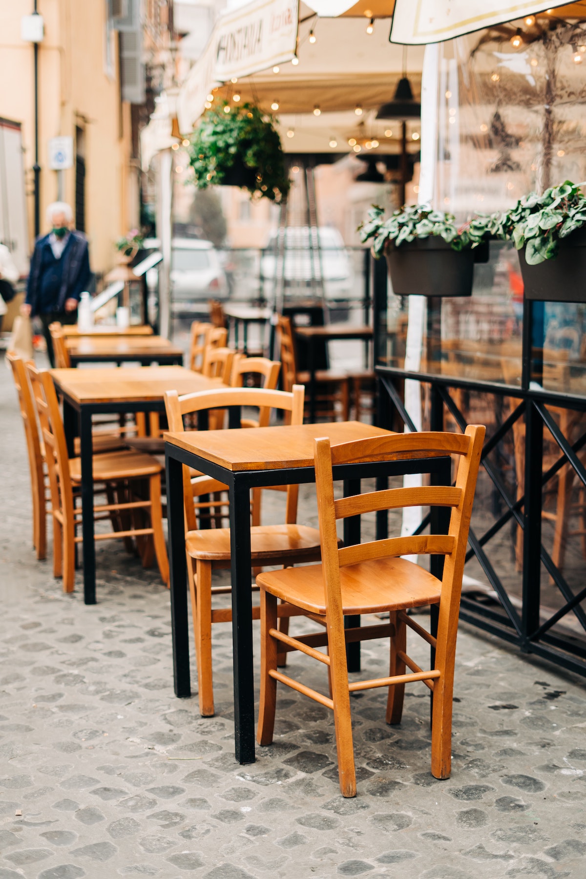Wooden tables and chairs at a sidewalk cafe in Italy