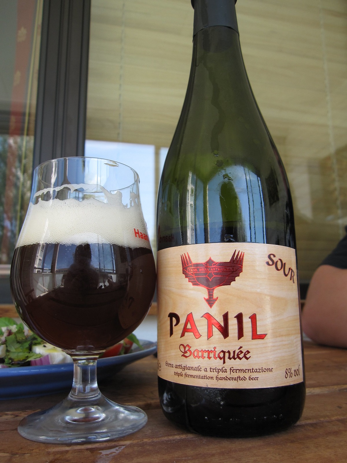 A large bottle of Panil Barriquee wine from Italy along with a mug of dark beer