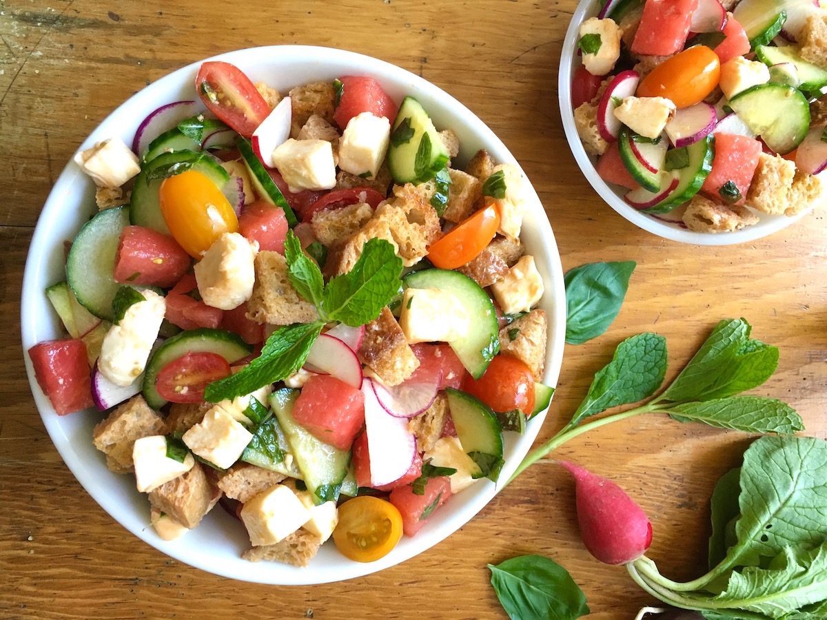 Overhead shot of one large and one small bowl of Tuscan bread salad with vegetables