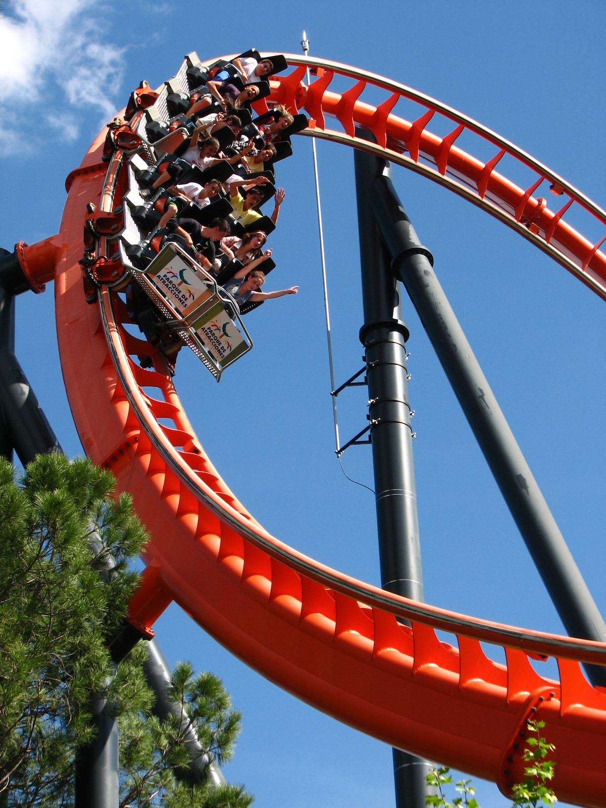 People riding a red roller coaster